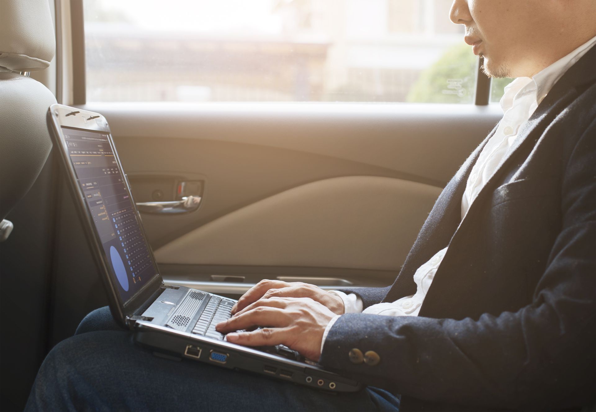 Young businessman using laptop work inside the car 